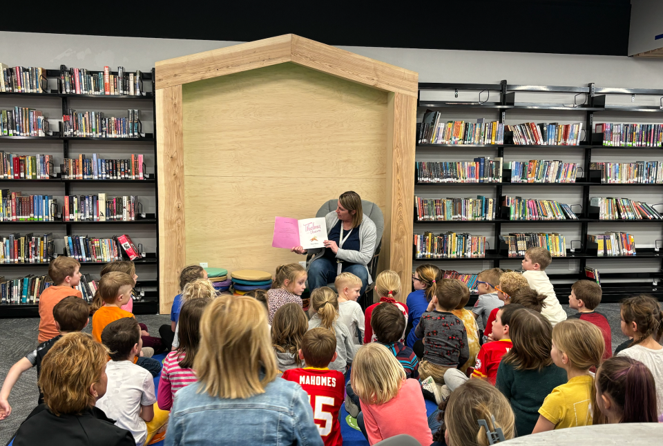 Teacher Jody Dvorak reads "Thelma the Unicorn" to students during the reveal of Earlham Community School District's refreshed library on Monday.