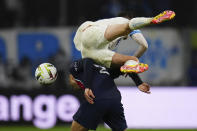 Marseille's Quentin Merlin jumps over PSG's Achraf Hakimi during the French League One soccer match between Marseille and Paris at the Velodrome stadium in Marseille, south of France, Sunday, March 31, 2024. (AP Photo/Daniel Cole)