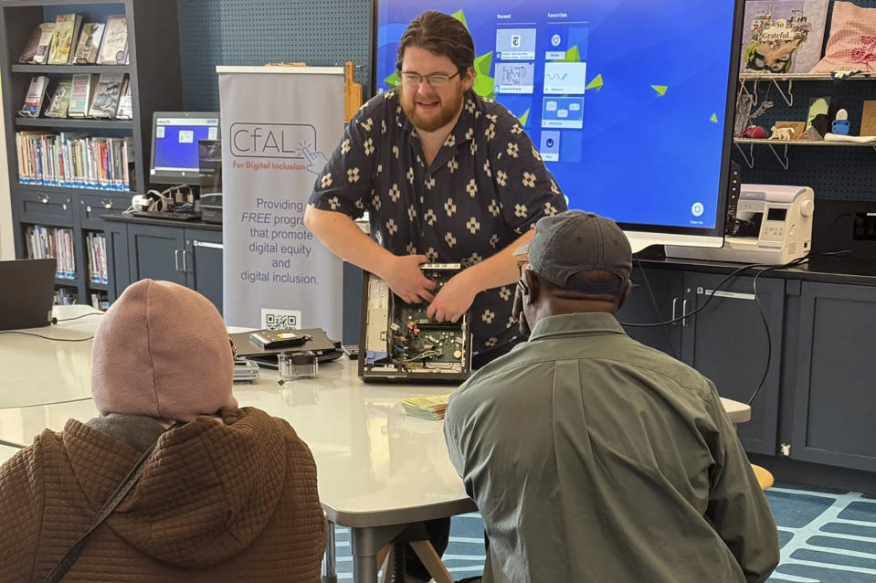 In this undated photo, Richie Hull, a lead instructor at the Connecticut-based group CfAL for Digital Inclusion, teaches participates at the Ives Maine Library in New Haven, Conn. how to take a computer apart and put it back together again. Connecticut is working on a new online academy to teach citizens about how to use generative artificial intelligence, but groups like CfAL say basic computer skills are also needed. (Rose Servetnick/CfAL for Digital Inclusion via AP)