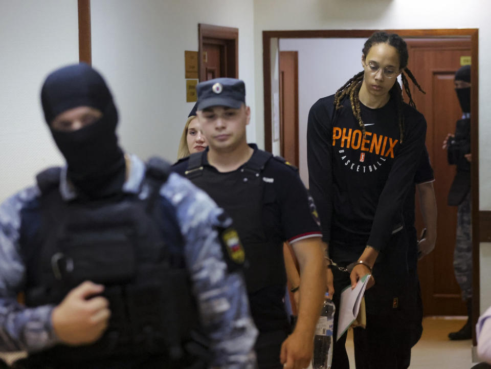 WNBA star and two-time Olympic gold medalist Brittney Griner is escorted to a courtroom for a hearing, in Khimki just outside Moscow, Russia, Wednesday, July 27, 2022. American basketball star Brittney Griner returned Wednesday to a Russian courtroom for her drawn-out trial on drug charges that could bring her 10 years in prison of convicted. (Evgenia Novozhenina/Pool Photo via AP)