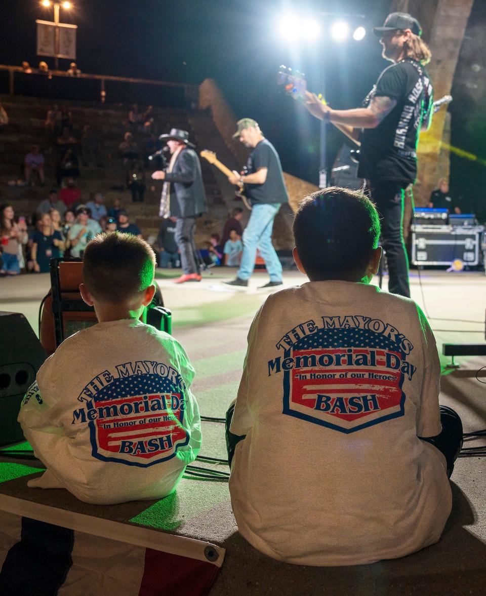 Two youngsters watch Eddie Montgomery perform May 27 during the Mayor's Memorial Day Bash at the Mort Glosser Amphitheatre.