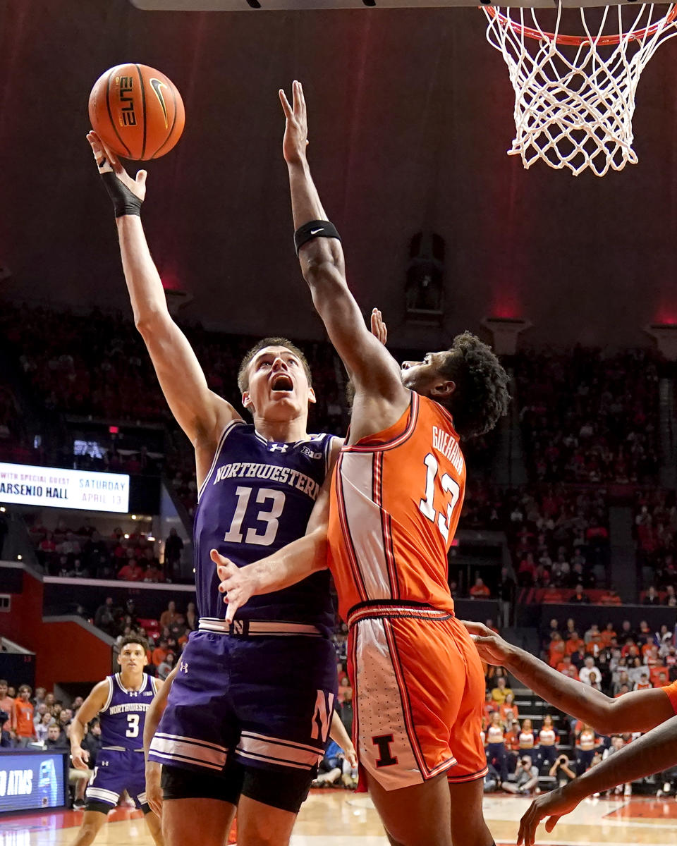 Northwestern's Brooks Barnhizer (13) drives to the basket as Illinois' Quincy Guerrier defends during the first half of an NCAA college basketball game Tuesday, Jan. 2, 2024, in Champaign, Ill. (AP Photo/Charles Rex Arbogast)