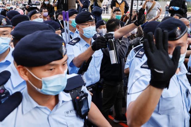 Police officers disperse supporters of pro-democracy activists outside a courthouse in Hong Kong.