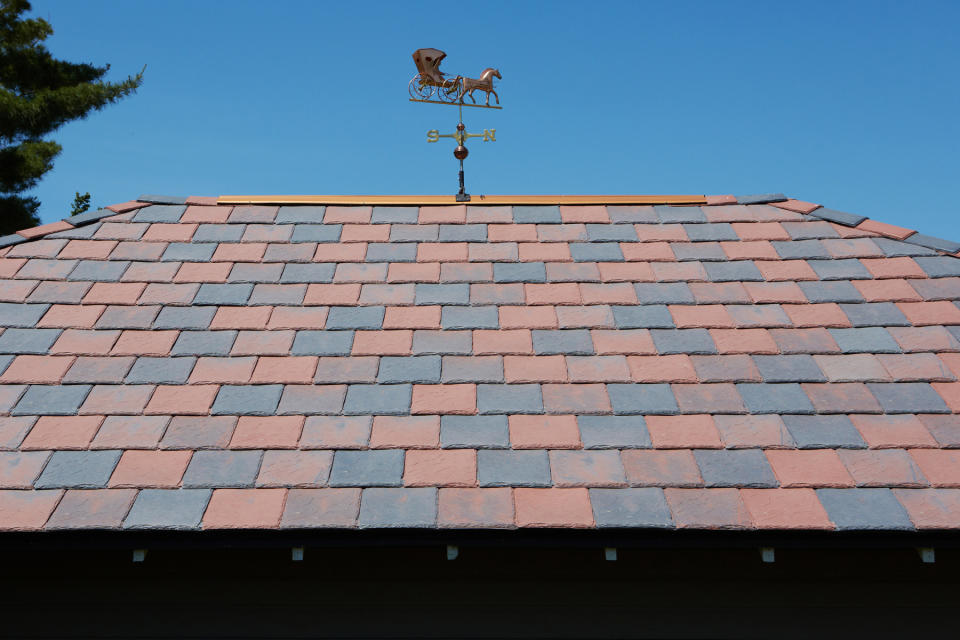 This 2012 photo provided by DaVinci Roofscapes shows a red and grey colored roof that replaced a storm damaged black one at Carol and Ray Knoff's home in Vinton, Iowa. The colors, produced by DaVinci Roofscapes, are typical of the original roofs on Victorian homes. (AP photo/DaVinci Roofscapes)