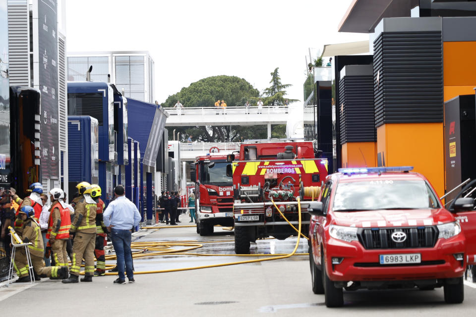 Firefighters work in the paddock after the McLaren F1 team were forced to evacuate its hospitality suite due to a fire during the 3rd practice session for the Formula 1 Spanish Grand Prix at the Barcelona Catalunya racetrack in Montmelo, near Barcelona, Spain, Saturday, June 22, 2024. The British team says there were no injuries. (AP Photo/Joan Monfort)