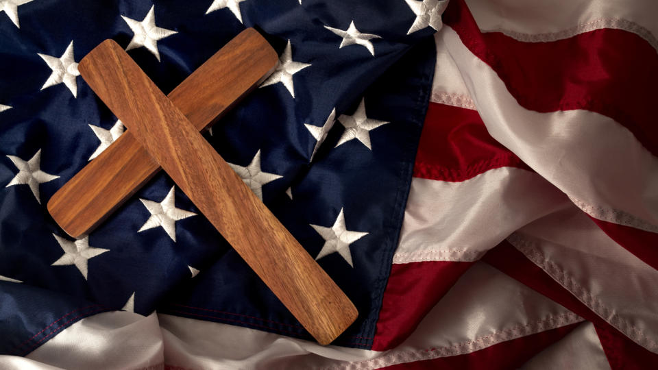 A cross lies on an American flag. 