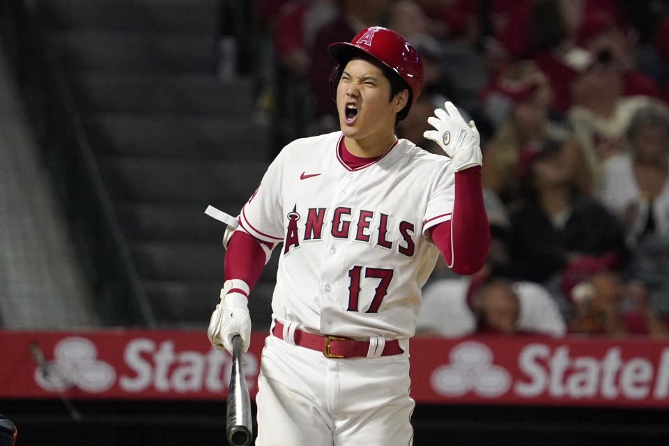Los Angeles Angels' Shohei Ohtani reacts after stinging his hand while hitting a foul ball during the seventh inning of a baseball game against the Houston Astros Wednesday, July 13, 2022, in Anaheim, Calif. (AP Photo/Mark J. Terrill)
