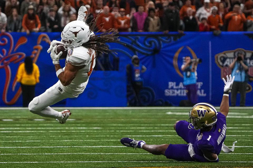 Texas wide receiver Jordan Whittington makes a catch over Washington cornerback Jabbar Muhammad during Monday night's 37-31 Sugar Bowl loss. The Longhorns' season ended at 12-2; the Huskies will face Michigan in next week's CFP championship game.