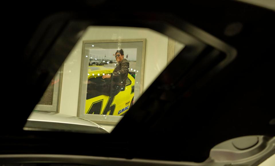 A photograph of actor Tom Cruise climbing out of the race car he used in the filming of the 1990 NASCAR-themed film u0022Days of Thunderu0022 is seen through the hood of one of the collectible cars inside the 58,000-square-foot Heritage Center in Concord, North Carolina, on July 25, 2023. In u0022Days of Thunder,u0022 a car salesman convinces a retired crew chief to work with a cocky young driver. It's based on Hendrick, his former driver Tim Richmond and crew chief Harry Hyde.
