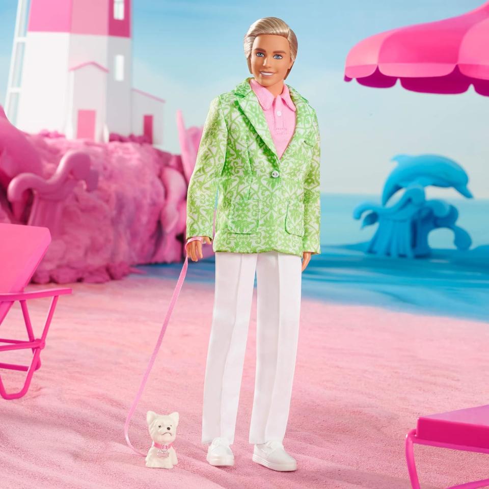 ken doll in green suit jacket, pink top and white pants with white puppy