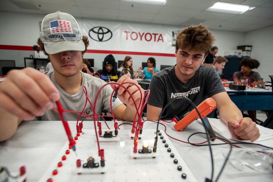 Cole Beninati, left, and Ryan Dingmon, both incoming seniors at Framingham High School, build circuits on a project board as part of MassBay's three-week automotive technology summer boot camp, July 27, 2023.