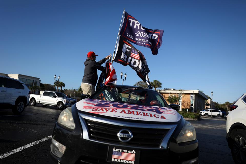 Justin Navarez, of Lake Worth, decorates his car with Trump flags outside the federal courthouse ahead of Trump's classified documents sealed hearing in Fort Pierce on Monday, Feb, 12, 2024.