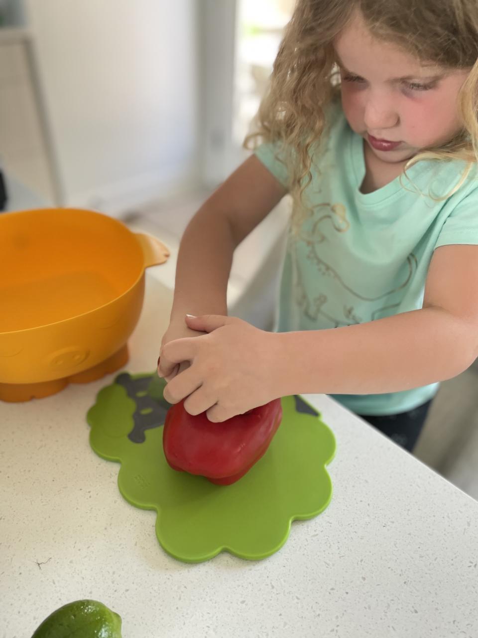 The author's daughter cutting a bell pepper