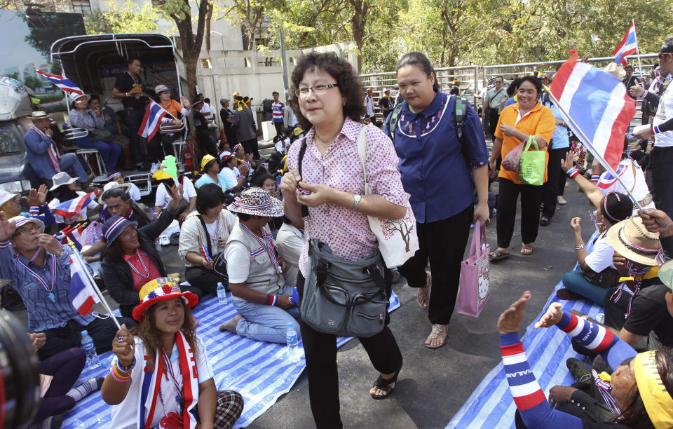 Thai civil servants of the Revenue Department walk through anti-government protesters who block and ask them to leave their office during a rally Monday, Jan. 13, 2014 in Bangkok, Thailand. Anti-government protesters aiming to shut down central Bangkok took over key intersections Monday, halting much of the traffic into the Thai capital's main business district as part of a months-long campaign to overthrow the democratically elected prime minister. (AP Photo/Apichart Weerawong)