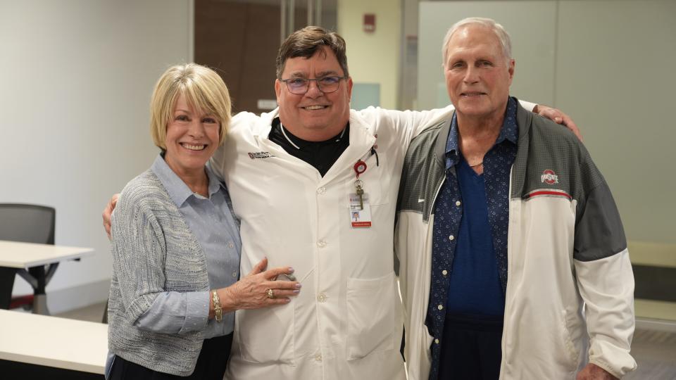 Ohio State University heart doctor Ralph Augostini (center) gets a big hug from Roosters restaurant founders Corrine and Bob Frick after the Fricks bought automated external defibrillators for each of their 15 corporate restaurants. On Wednesday, Jan. 3, 2024 Wexner Medical Center staff members gave AED and first aid training to managers from the popular restaurant chain. The Fricks have supported various heart-related endeavors at the university since Bob developed various severe heart issues.