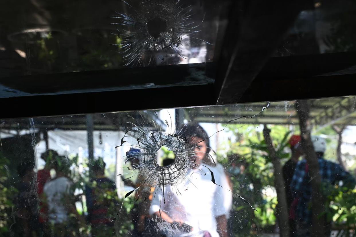 A woman looks at a bullet hole on a glass cover of a food stall in Yangon on March 4, 2021, a day after where protesters were shot and died by gun fire as security forces dispersed a demonstration against the military coup. (Photo by STR / AFP) (Photo by STR/AFP via Getty Images)