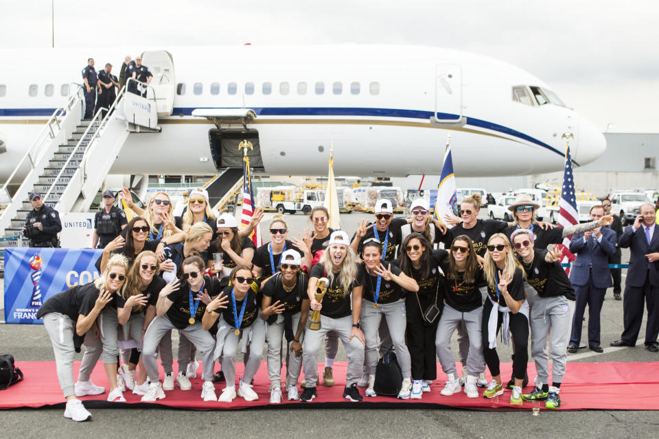 NEWARK, NJ - JULY 08: Julie Ertz #8 of United States holds the FiFA Women's World Cup Championship Trophy and is joined by other members of the U.S. Women's World Cup Championships team wearing a shirt that says World Champions 2019 as the USA Women's National team arrives back in the U.S. after winning their 4th FIFA World Cup title against Netherlands at Newark Liberty International Airport on July 08, 2019 in Newark, NJ, USA. (Photo by Ira L. Black/Corbis via Getty Images)