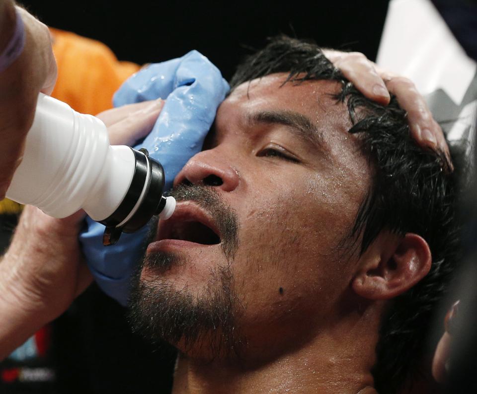 Manny Pacquiao, from the Philippines, is assisted in his corner during his welterweight title fight against Floyd Mayweather Jr. on Saturday, May 2, 2015 in Las Vegas. (AP Photo/John Locher)