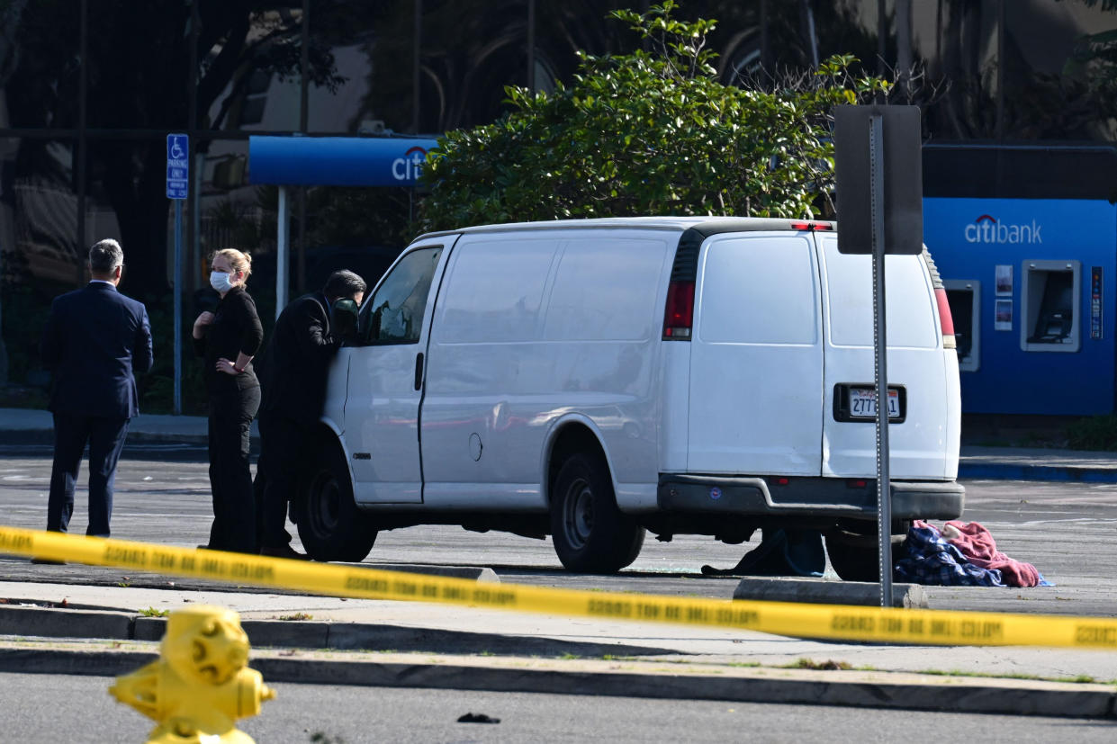 Officers peer into the window of a van believed to have a body in the driver's seat in Torrance (Robyn Beck / AFP - Getty Images)