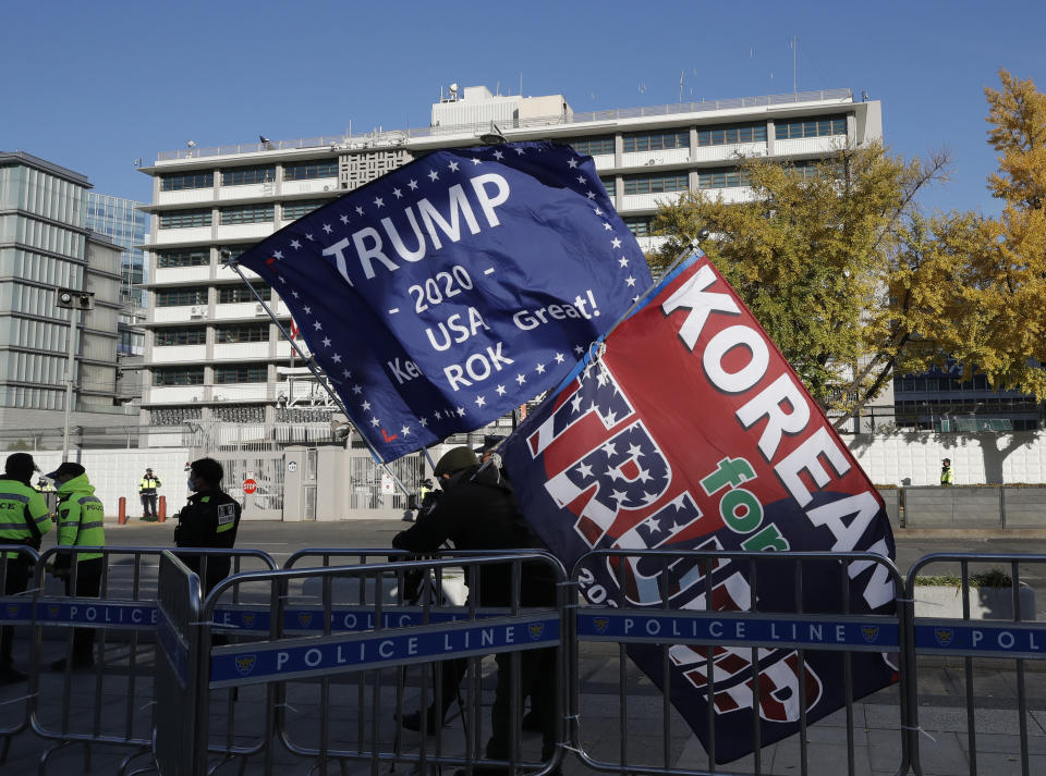 South Korean supporters of U.S. President Donald Trump hold flags near the U.S. Embassy in Seoul, South Korea, Wednesday, Nov. 4, 2020. (AP Photo/Lee Jin-man)