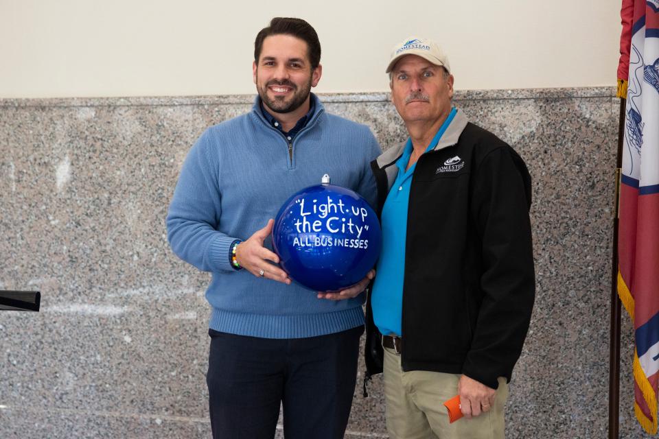 Mayor Scott Conger presents David Markowski with the “Light Up the City” award for his business Homestead Pest Management in the Light Up Jackson contest on Monday, January 9, 2023, at city hall in Jackson, Tenn.