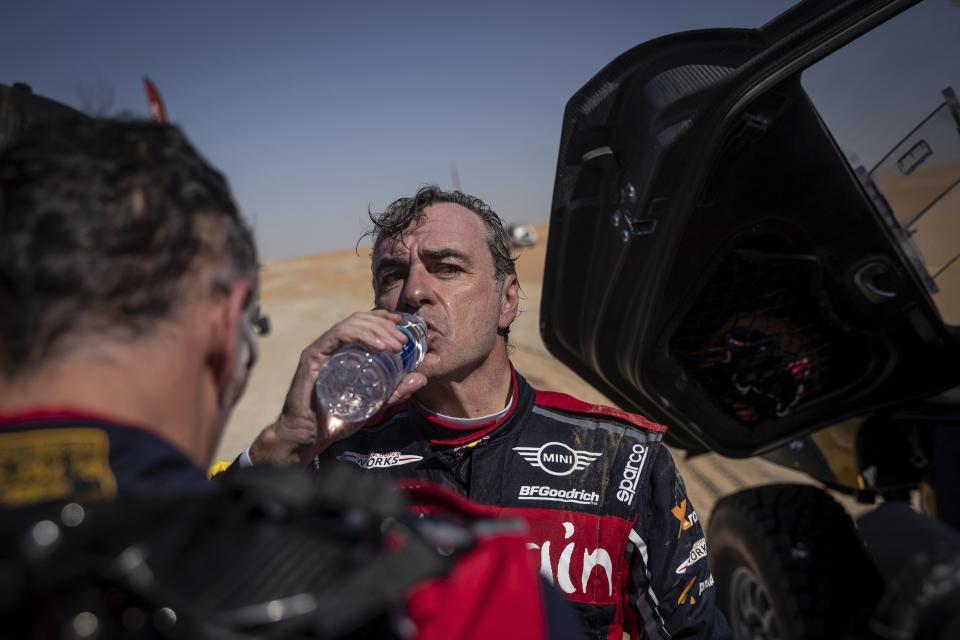 Driver Carlos Sainz, of Spain, drinks water during stage eleven of the Dakar Rally between Shubaytah and Haradth, Saudi Arabia, Thursday, Jan. 16, 2020. (AP Photo/Bernat Armangue)