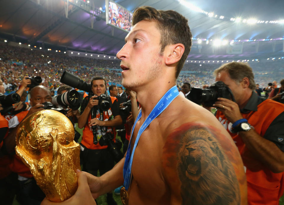 RIO DE JANEIRO, BRAZIL - JULY 13: Mesut Oezil  of Germany celebrates with the World Cup trophy  after defeating Argentina 1-0 in extra time during the 2014 FIFA World Cup Brazil Final match between Germany and Argentina at Maracana on July 13, 2014 in Rio de Janeiro, Brazil.  (Photo by Martin Rose/Getty Images)