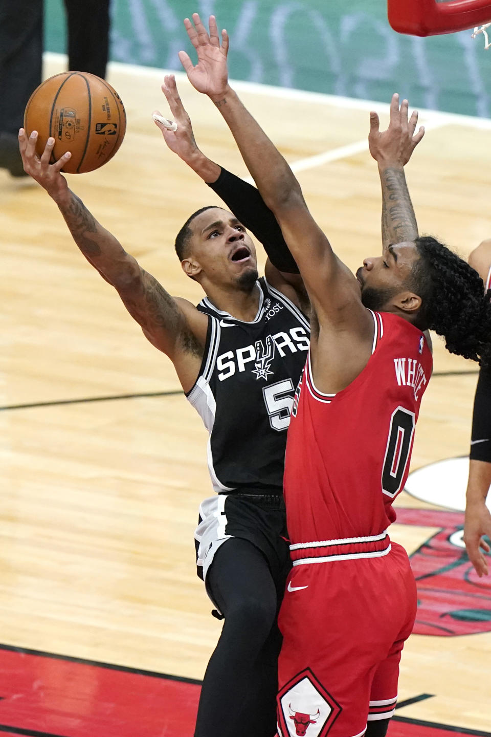 San Antonio Spurs guard Dejounte Murray, left, drives to the basket as Chicago Bulls guard Coby White guards during the first half of an NBA basketball game in Chicago, Wednesday, March 17, 2021. (AP Photo/Nam Y. Huh)