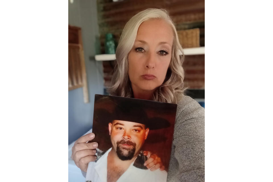 Jenifer Jones holds a photo of her deceased brother, John Wayne Dodge, on Wednesday, Nov. 2, 2023, at her home in San Jacinto County, Texas. Jones, 47, said she reached out to the FBI about what she feels was San Jacinto County Sheriff Greg Capers' office's botched investigation of her bother's fatal shooting and said agents questioned her for hours, asking about events well beyond her brother's case and collecting records accusing the sheriff and his staff of wide-ranging misconduct. (Jenifer Jones via AP)