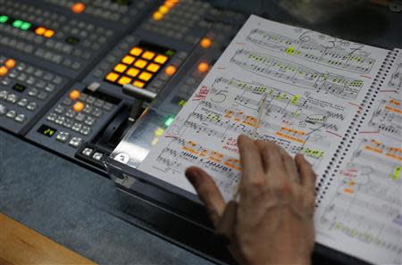 A member of the broadcast team follows the musical score during a live transmission of the opera "Parsifal" from the Royal Opera House in London December 18, 2013. REUTERS/Suzanne Plunkett