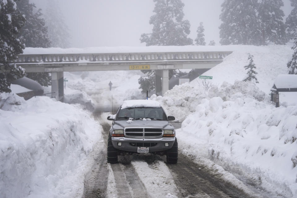 FILE - A truck drives along snow berms in Running Springs, Calif., Tuesday, Feb. 28, 2023. Since December, 2022, a parade of a dozen atmospheric storms have dumped so much snow up and down the Sierra that several ski resorts around Lake Tahoe have had to shut down multiple times. The National Weather Service in Reno recently called it the "winter that just doesn't want to end." (AP Photo/Jae C. Hong, File)