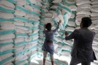 Workers handle sacks of wheat flour at a World Food Programme food aid distribution center in Sanaa