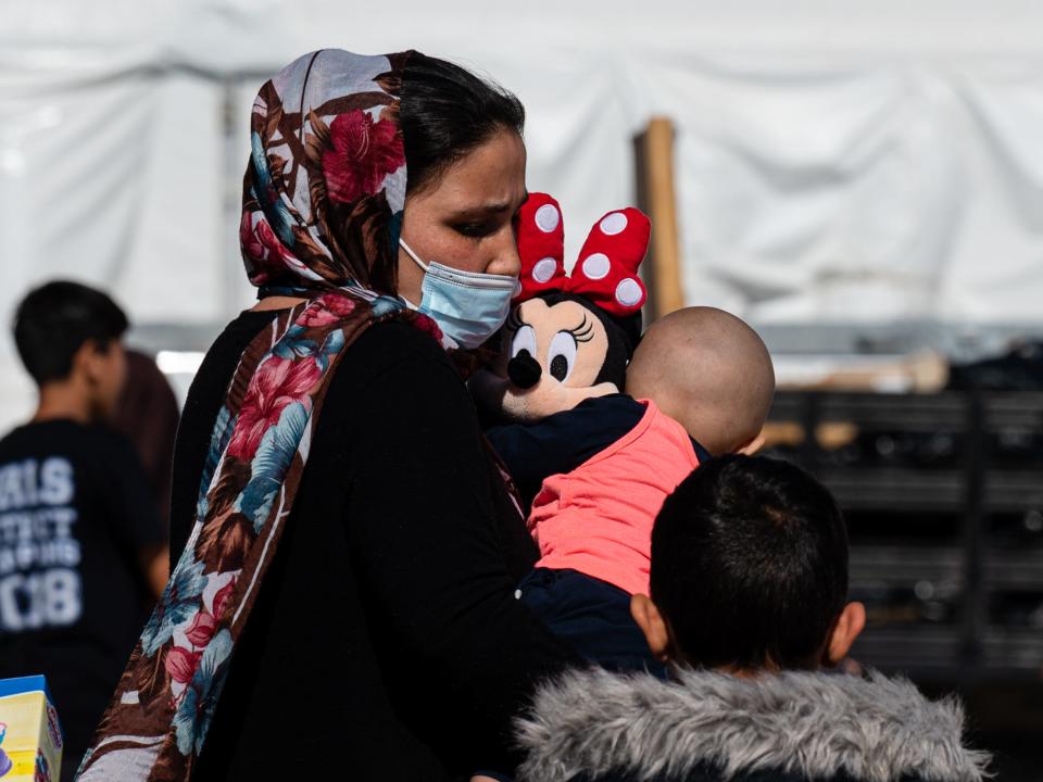 An Afghan mother and her children walk through a refugee camp in New Mexico.