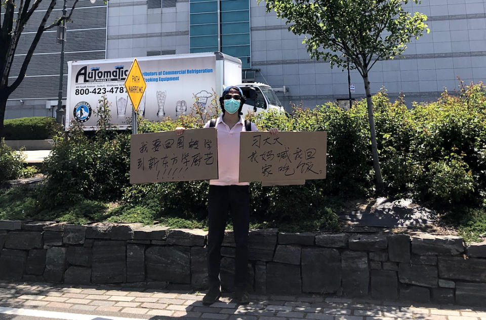 Recent New York University graduate Jiang Li says he has been trying to purchase tickets back to China since April but has been unable to return. Late last month, he showed up to the Chinese Consulate in New York with a sign saying that his mom is waiting on him for dinner back home. (Courtesy Jiang Li)