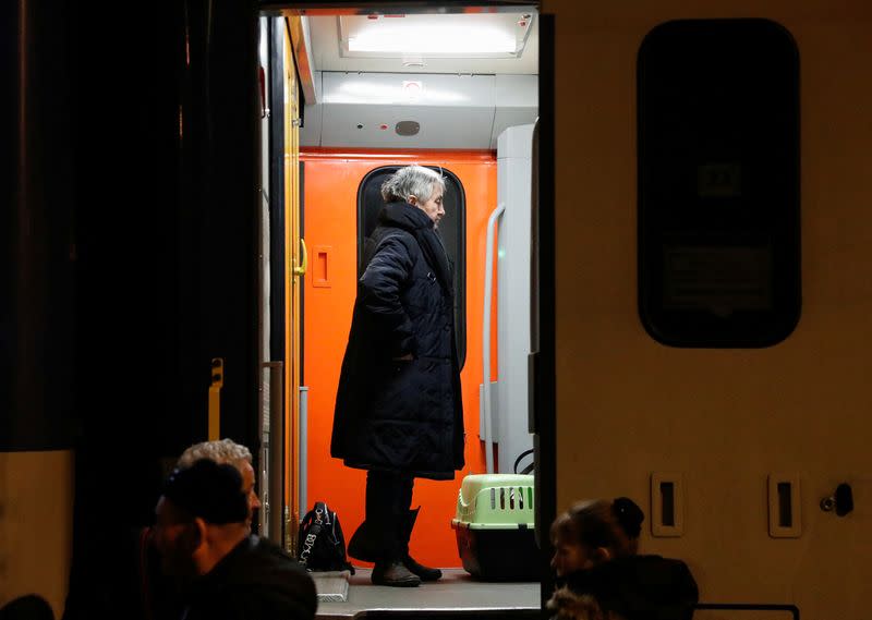 People fleeing Russia's invasion of Ukraine get on a train, in Zahony