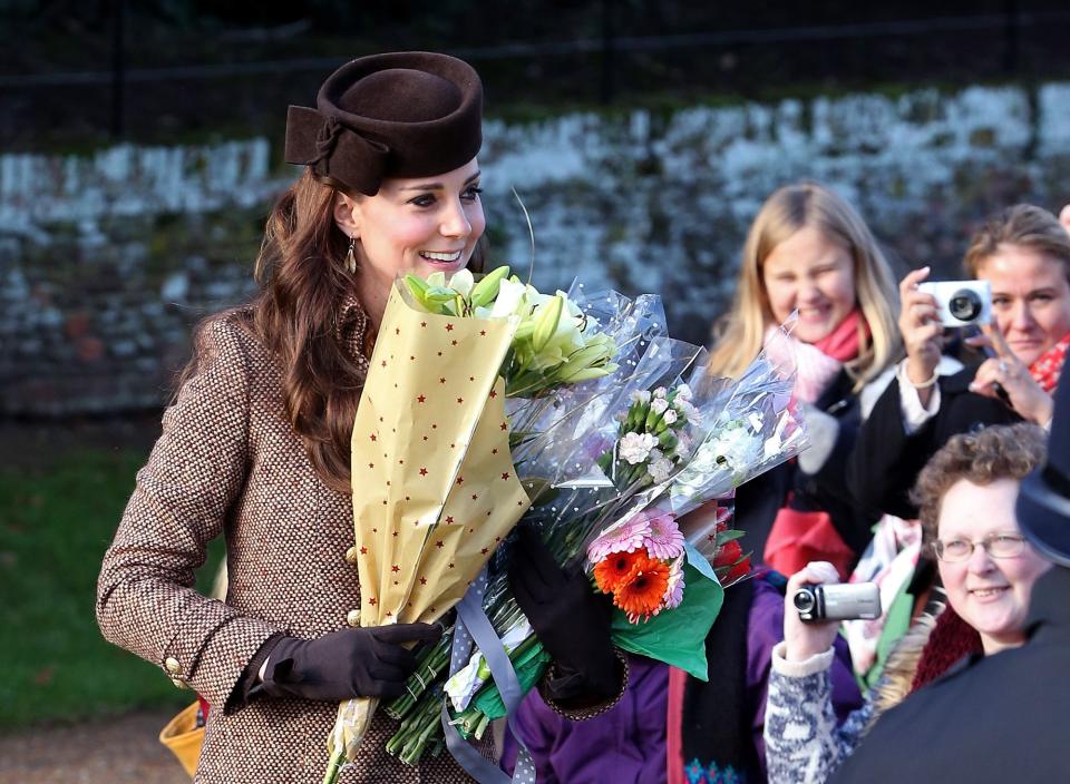 Catherine, Duchess of Cambridge, collects flowers from well-wishers at a Christmas Day church service near Sandringham on December 25, 2014.