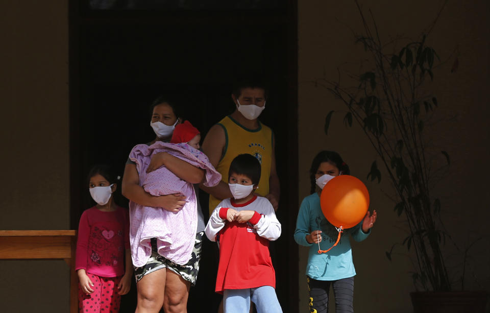 A family takes a walk in the garden of a religious property being used as a government-run shelter where citizens returning home are required by law to quarantine for two weeks and pass two consecutive COVID-19 tests, as a preventive measure amid the COVID-19 pandemic on the outskirts of Asuncion, Paraguay, Thursday, June 18, 2020. While Paraguay appears to be controlling the disease, it faces concerns about a predicted 5% drop in gross domestic product for an economy that was already struggling, and a health system that remains unprepared for a large-scale epidemic. (AP Photo/Jorge Saenz)