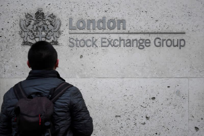 FILE PHOTO: A pedestrian in front of the London Stock Exchange offices