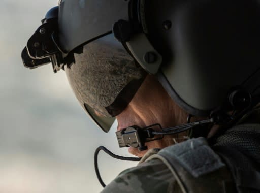 A partial view of the Iraqi capital is reflected in the visor of a US army helicopter crew member as he looks out of a Chinook helicopter over Baghdad on January 9, 2019