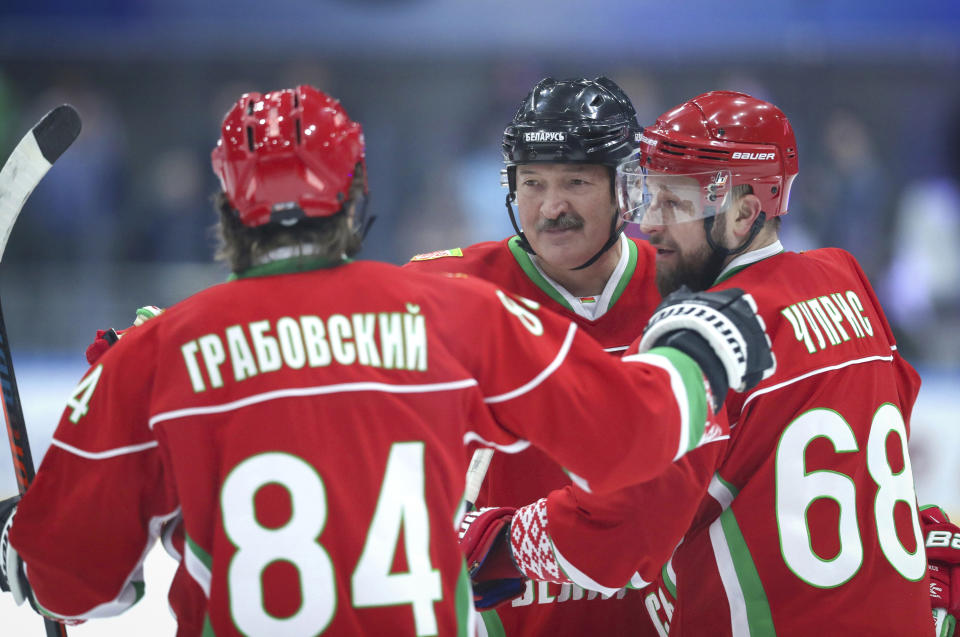 FILE - In this photo taken on Saturday, March 28, 2020, Belarusian President Alexander Lukashenko, centre, takes part in a hockey match during Republican amateur competitions in Minsk, Belarus. From the U.S. president to the British prime minister's top aide and far beyond, leading officials around the world are refusing to wear masks or breaking confinement rules meant to protect their populations from the coronavirus and slow the pandemic. While some are punished when they're caught, or publicly repent, others shrug off the violations as if the rules don't apply to them. (Andrei Pokumeiko/BelTA Pool Photo via AP, File)