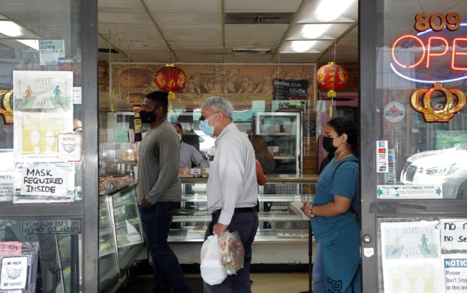 Customers wear masks inside a bakery.