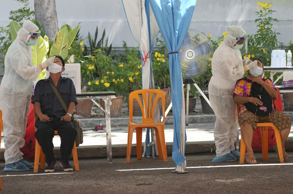 Health workers collect nasal swabs from local residents for coronavirus testing in Bangkok, Thailand, Tuesday, June 1, 2021. (AP Photo/Sakchai Lalit)