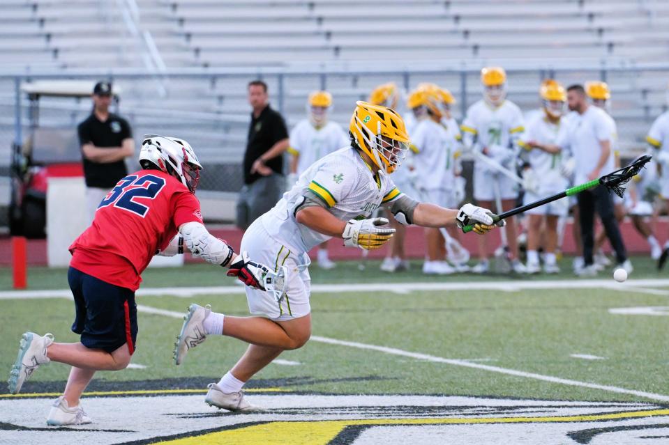 Jupiter's Dylan Furshman extends his arm toward teammates after winning a faceoff during a regular season game against Oxbridge Academy on Mar. 26, 2024.