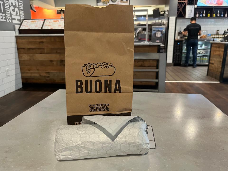 A Buona bag and a sandwich wrapped in foil.