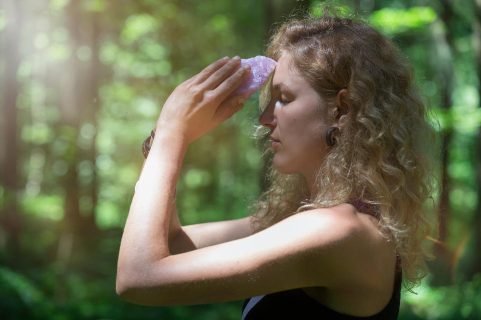 person putting a large crystal to their forehead