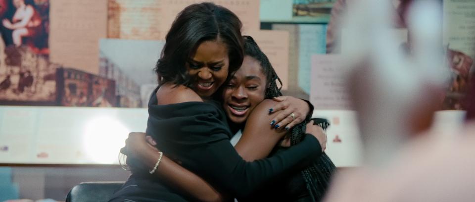 Michelle Obama (left) hugs a young fan at a Philadelphia community event in a scene from the Netflix documentary "Becoming."