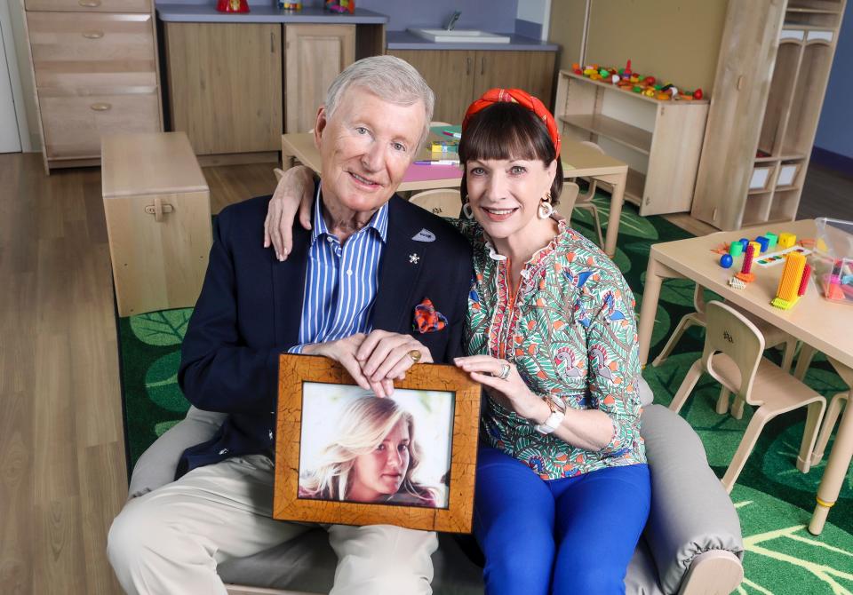 David and  Jillian Gilmour inside the Erin H. Gilmour Learning Center holding a photo of Erin Gilmour.