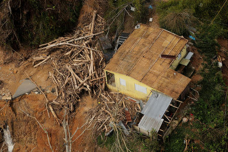 FILE PHOTO: Debris left by a flooded river stands piled against a home seen from the air during recovery efforts following Hurricane Maria near Utuado, Puerto Rico October 10, 2017. REUTERS/Lucas Jackson/File Photo