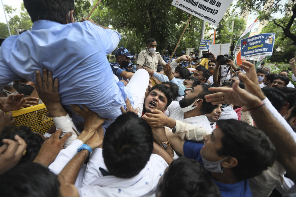 Congress party workers help their leader cross over a police barricade during a protest accusing Prime Minister Narendra Modi’s government of using military-grade spyware to monitor political opponents, journalists and activists in New Delhi, India, Tuesday, July 20, 2021. The protests came after an investigation by a global media consortium was published on Sunday. Based on leaked targeting data, the findings provided evidence that the spyware from Israel-based NSO Group, the world’s most infamous hacker-for-hire company, was used to allegedly infiltrate devices belonging to a range of targets, including journalists, activists and political opponents in 50 countries. (AP Photo/Manish Swarup)