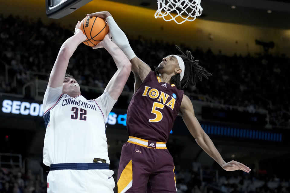 Iona's Daniss Jenkins (5) blocks a shot by Connecticut's center Donovan Clingan (32) in the first half of a first-round college basketball game in the NCAA Tournament, Friday, March 17, 2023, in Albany, N.Y. (AP Photo/John Minchillo)